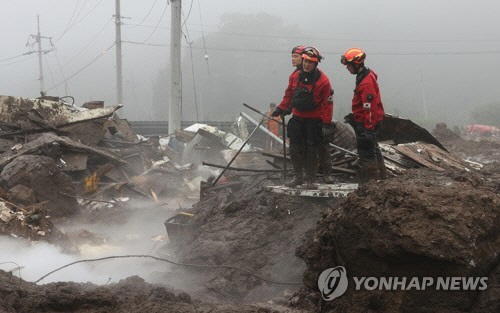 16일 오전 경북 예천군 백석리 산사태 현장에서 구조 대원과 수색견이 발이 푹푹 빠지는 진창에서 수색을 계속하고 있다. 이 마을에서는 산사태로 주택 5가구가 매몰돼 사망자 3명, 실종자 2명이 발생했다. [예천=연합뉴스]